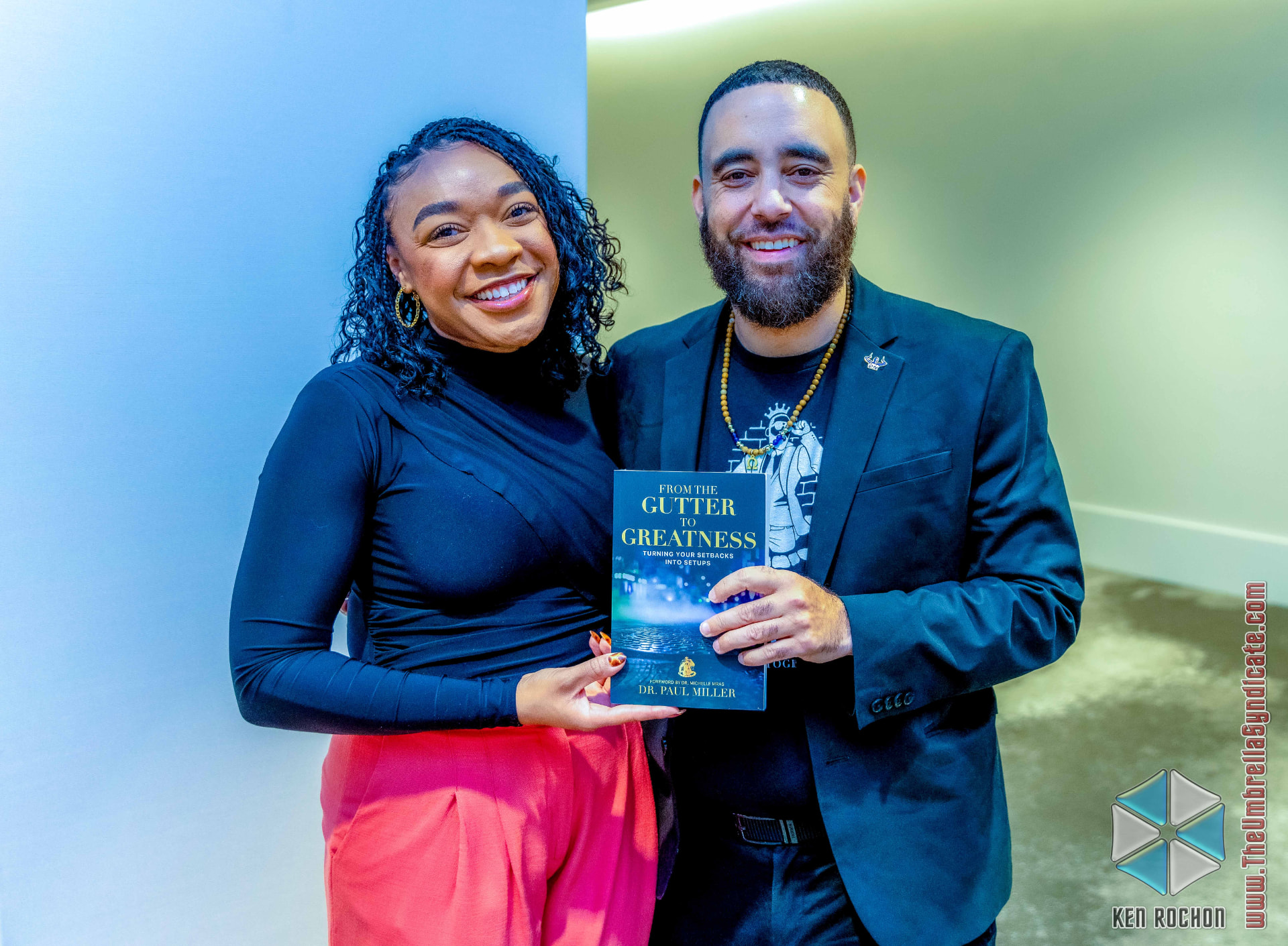 Dr. Miller and a reader holding From the Gutter to Greatness